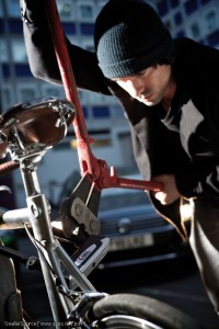 Mann mit Bolzenschneider versucht ein Fahrradschloss zu knacken