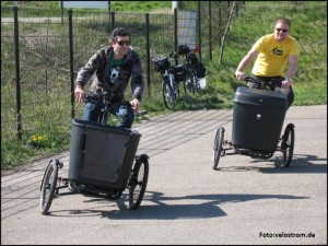 Zwei Männer fahren auf je einem Lastenrad mit Neigetechnik