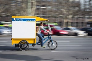 Eine Frau fährt auf einem Lastenrad von Velogista