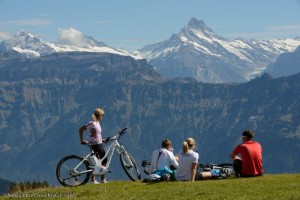 Menschen mit Farhrrädern vor Alpenpanorama