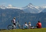 Menschen mit Rad vor Alpenpanorama