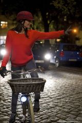 Foto einer Frau auf dem Rad im Dunkeln mit aktiviertem Blinkerhandschuh