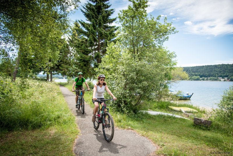 Ein Paar ist mit dem MTB an einem See.