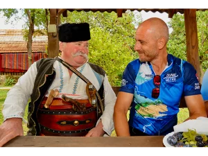 Radfahrer im Trikot und Mann in bulgarischer Tracht